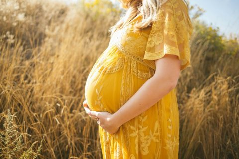 Gestante ao ar livre segurando a barriga