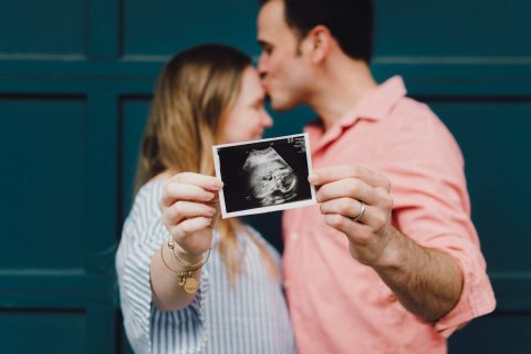 Casal segurando a imagem de um exame de ultrassom